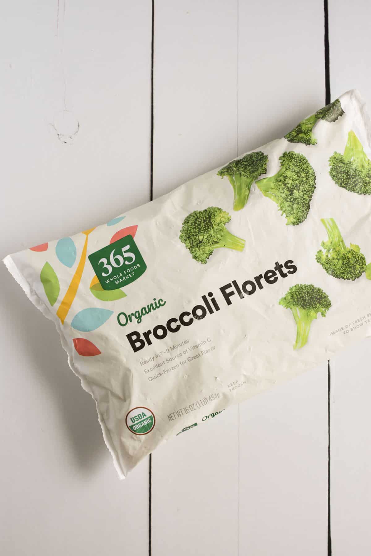 bag of frozen broccol florets on a table.