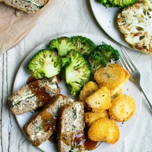 Overhead of vegan dinner on a plate with vegan loaf, potatoes and broccoli.