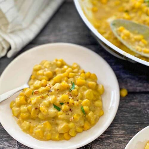 Creamed corn on a plate with a spoon.