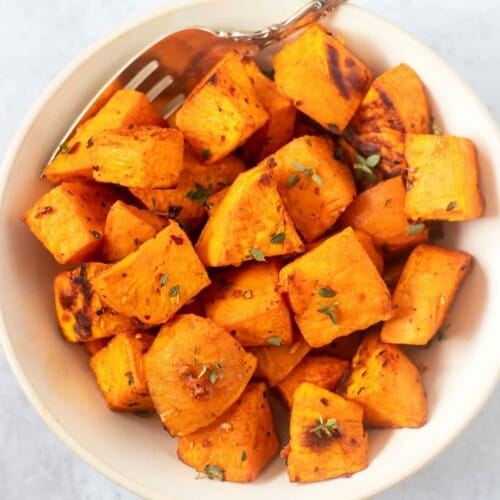Cubes of sweet potatoes in a white bowl.