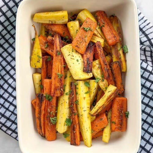 Orange and yellow root vegetables cooked in a casserole dish.