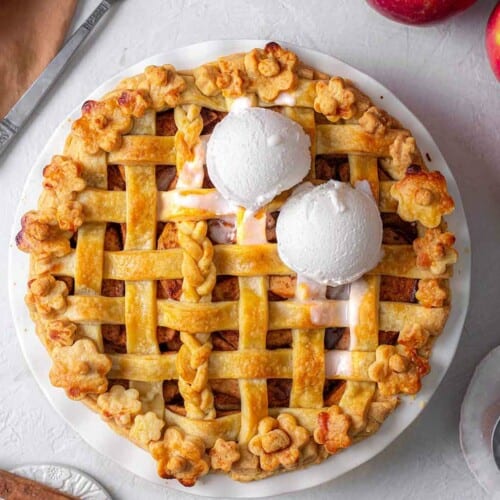 Apple pie with criss cross crust and scoops of ice cream.