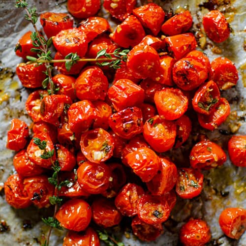 cherry tomatoes on parchment paper after roasting.