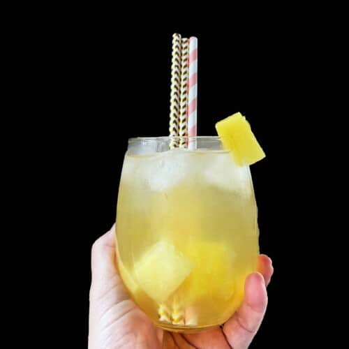 pineapple drink in a glass with straws.