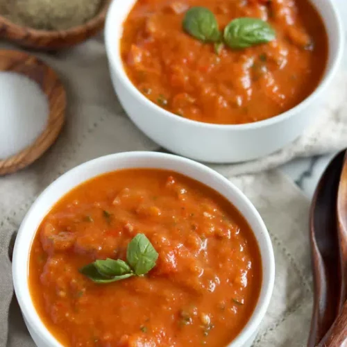vegan roasted red pepper tomato souop in two white bowls.