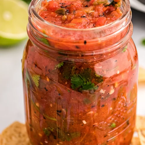 front view of slow cooker salsa in a mason jar.