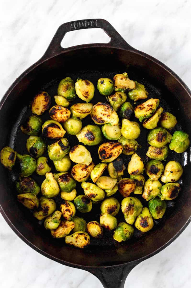 Browned brussels sprouts in a cast-iron skillet.
