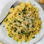Microwave cooked pasta served on a white plate and topped with grated parmesan cheese and chopped parsley.