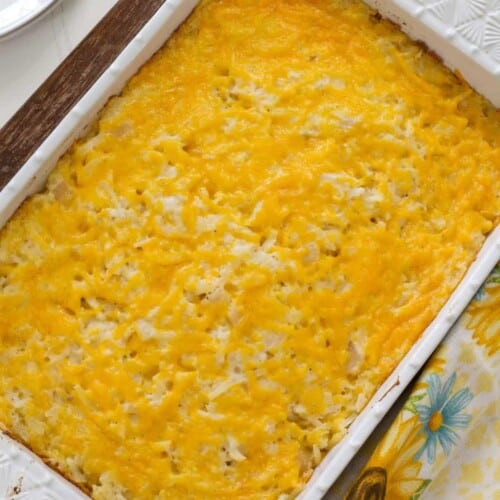 A casserole dish filled with baked Vegetarian Cracker Barrel Hashbrown Casserole in it with.