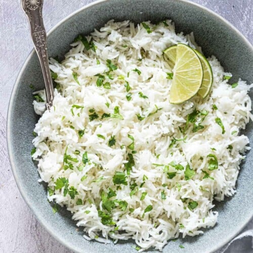 Top down view of Instant pot Cilantro Lime Rice served in a bowl with a silver serving spoon.