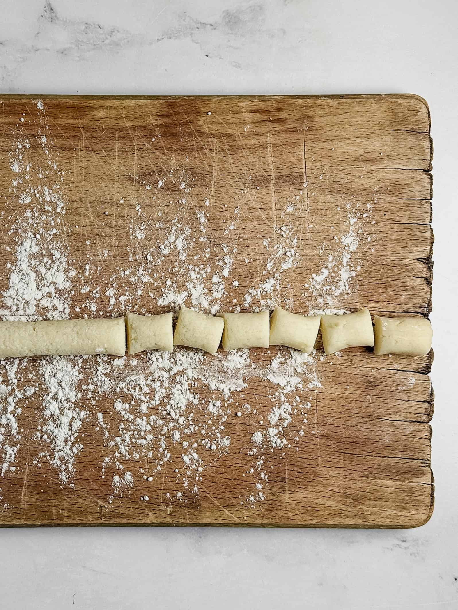 Gnocchi on wood board.