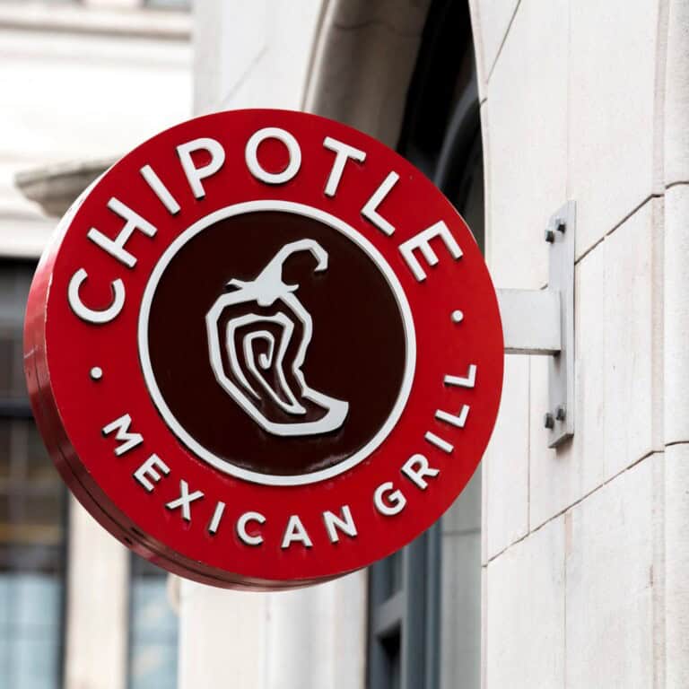 Chipotle Logo hanging on the concrete wall - feature image for vegan options at chipotle article