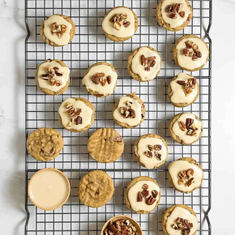 maple pecan cookies on a rack with a few topped with maple glaze and pecans - feature
