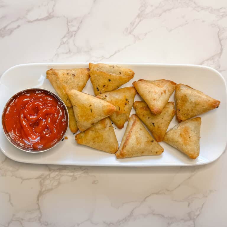 air fryer frozen samosas served on a white plate with ketchup on the side