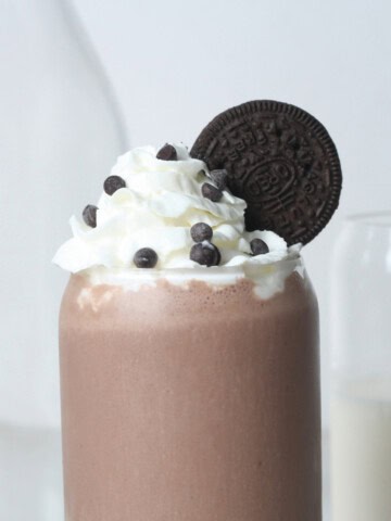 Chocolate-oreo-protein-shake-side-shot-with-dairy-free-whipped-cream and Oreo on the side
