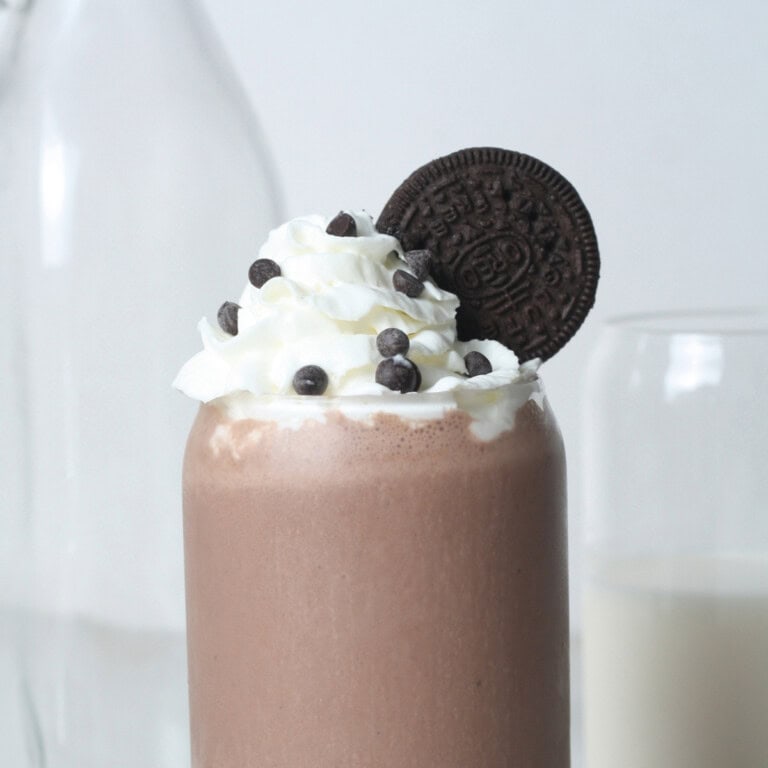 Chocolate-oreo-protein-shake-side-shot-with-dairy-free-whipped-cream and Oreo on the side