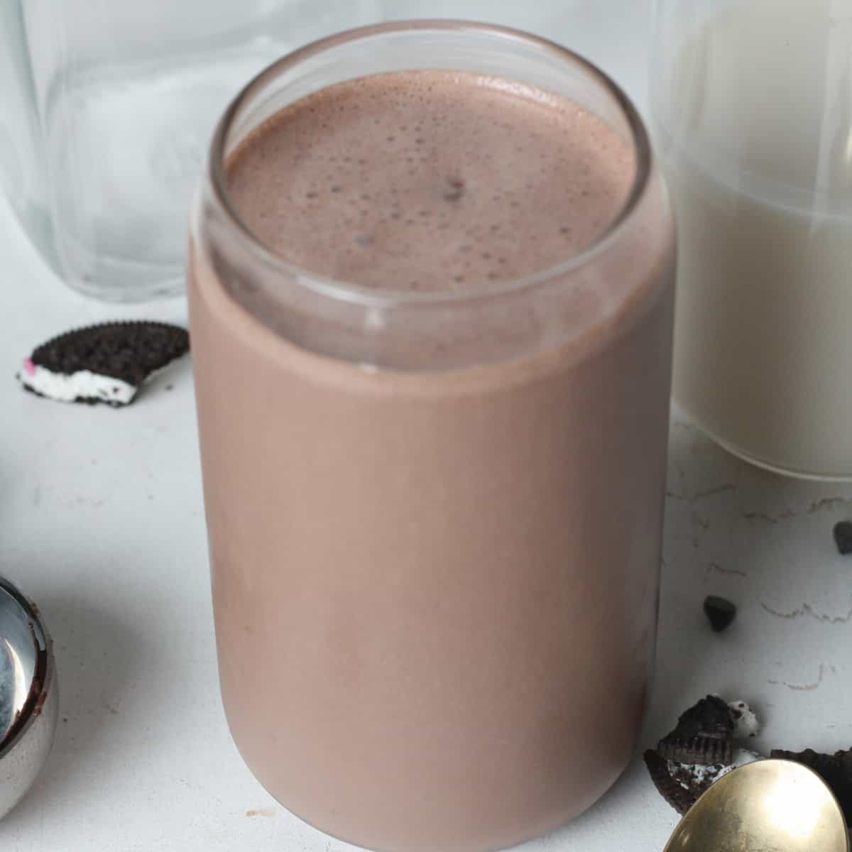 close up image of vegan Oreo protein shake in a glasss. Side image
