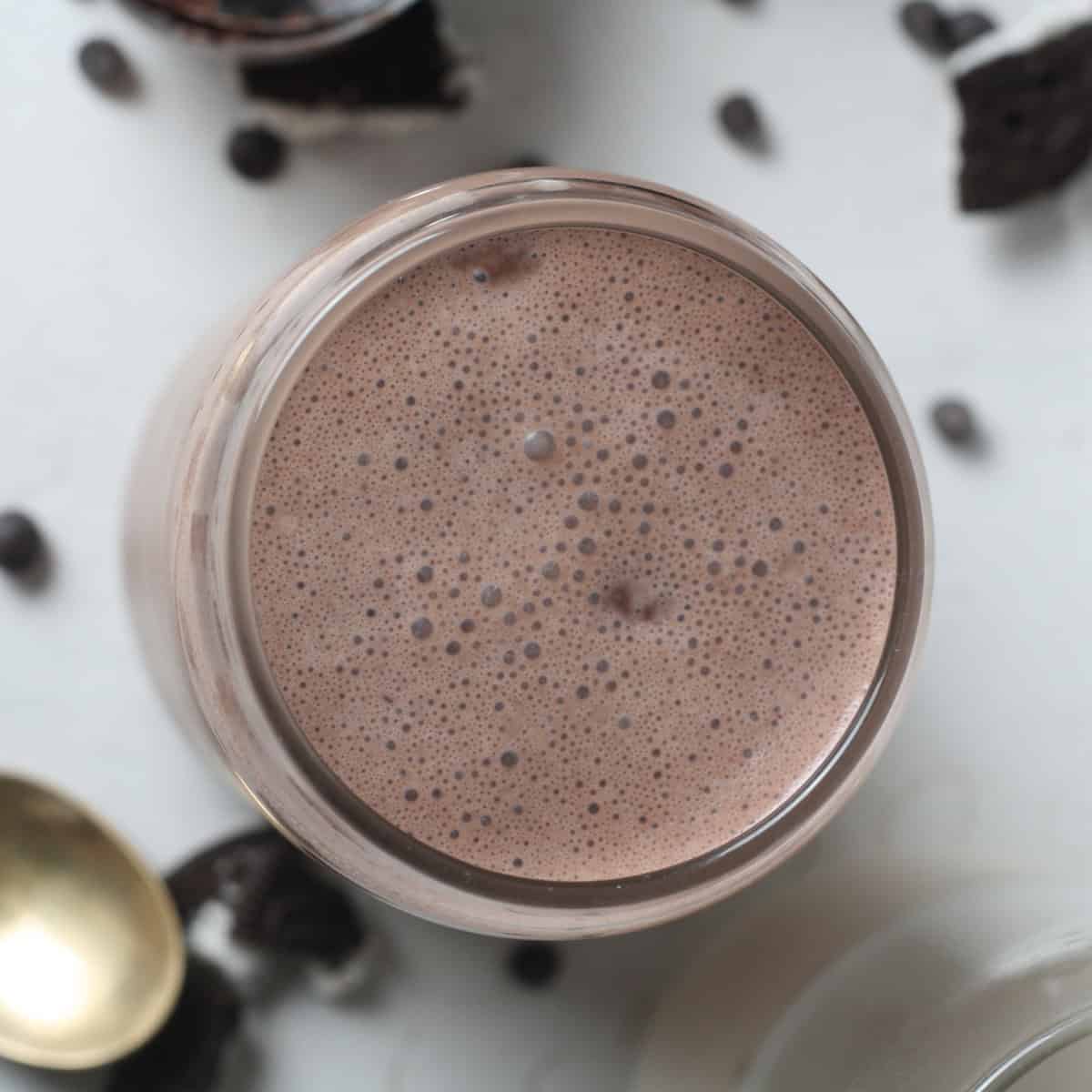 Overhead shot of oreo protein shake with chocolate crumbs on the side