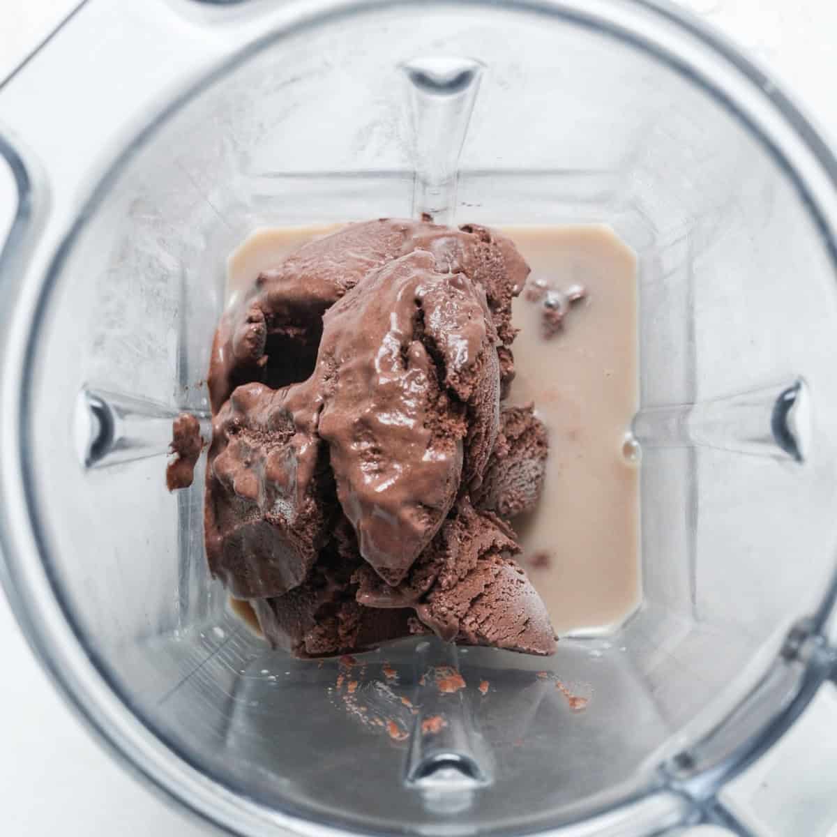 dairy free ice cream, protein powder and milk in the blender to make cookies and cream vegan protein shake.