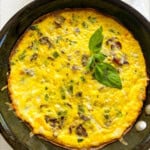Veggie Loaded Frittata in the pan with basil leaf as garnish