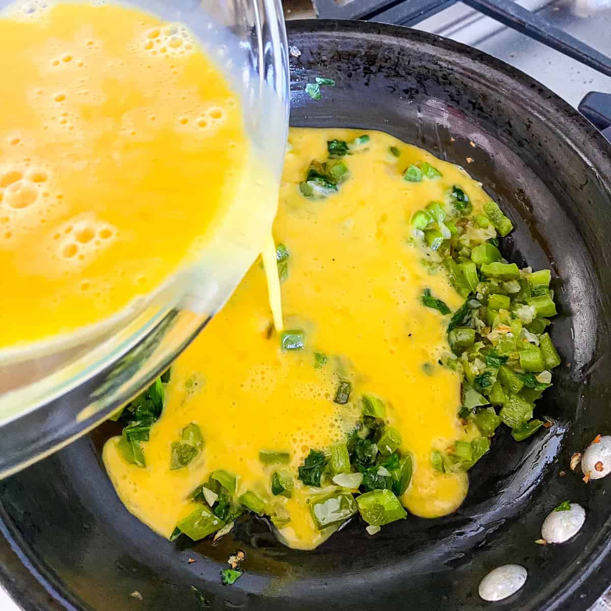 Pour the egg mixture over the cooked vegetables