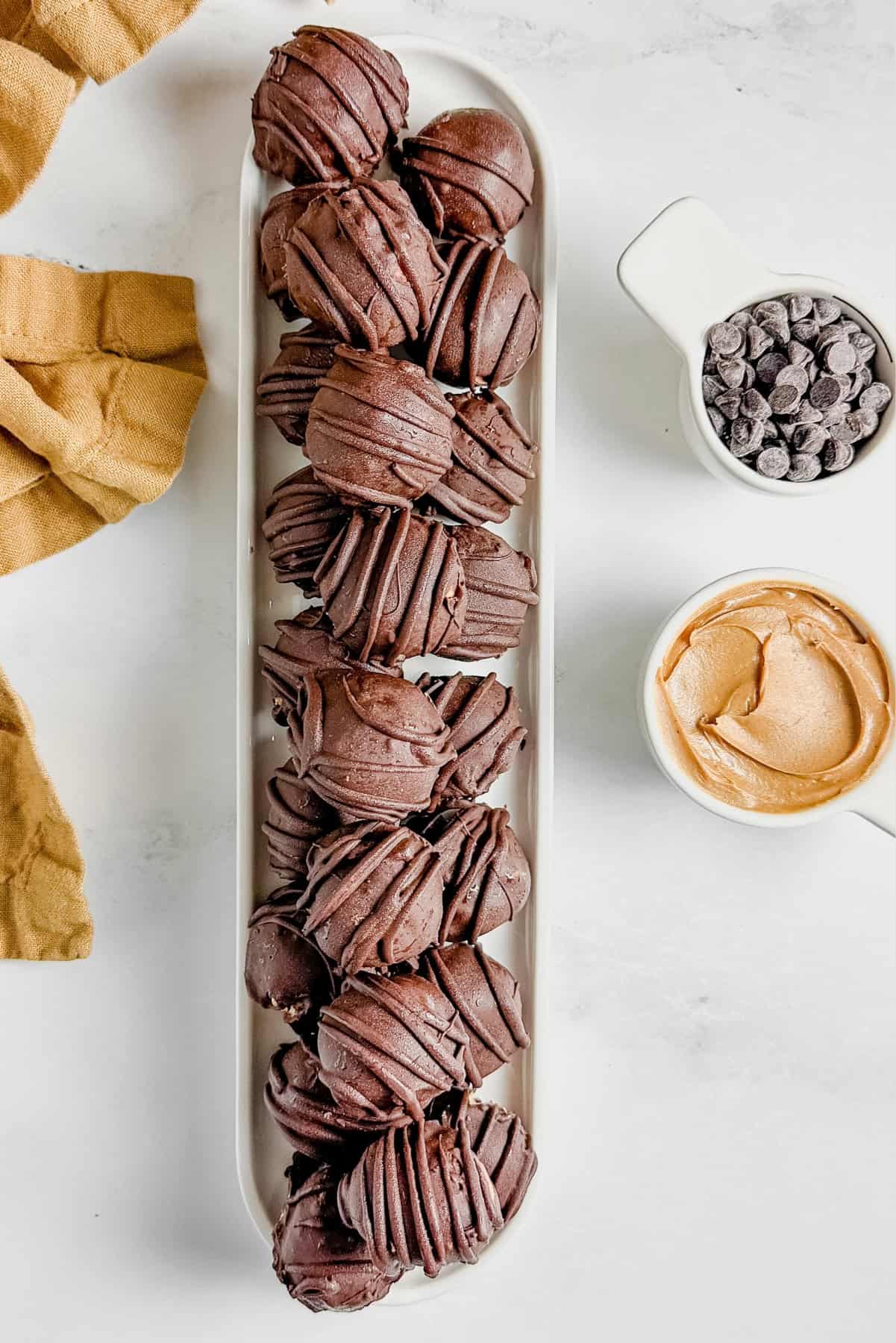 Set of chocolate peanut butter truffles on white serving tray 