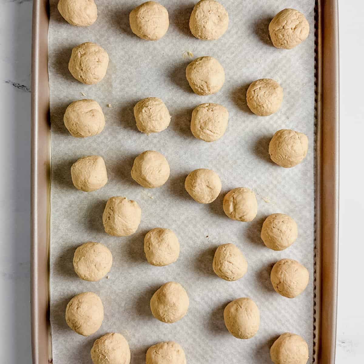 Peanut butter dough balls set on sheet pan