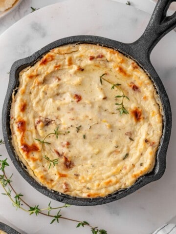 Baked Ricotta Dip in an Iron cast pan with fresh herbs on the side