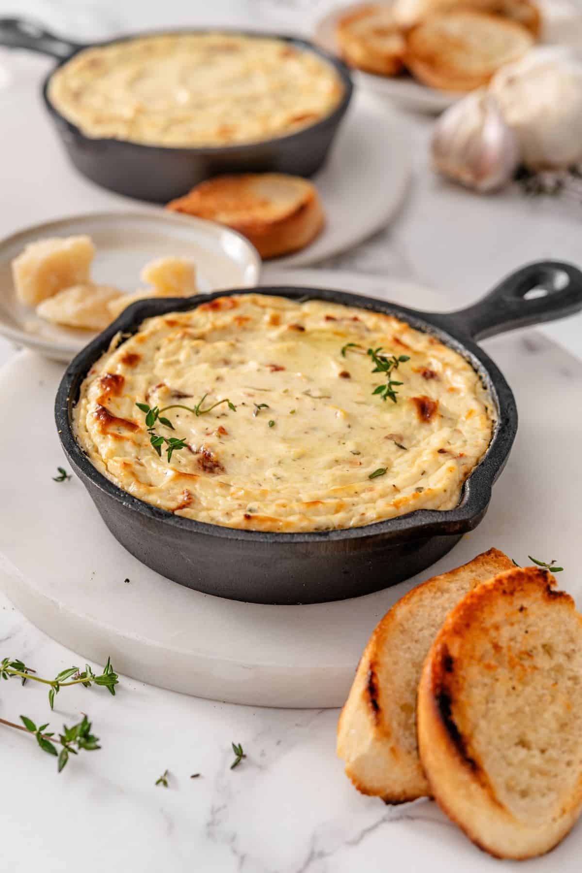 Set of 2 baked ricotta dips with bread and cheese taken out of the oven