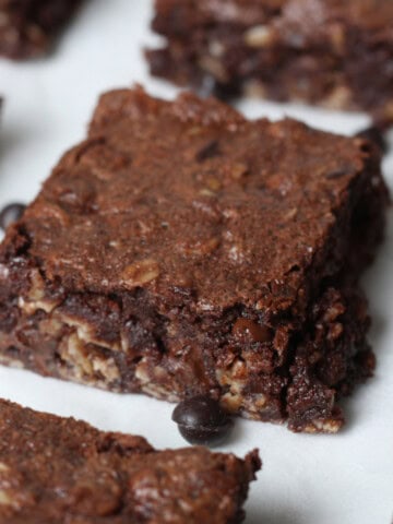 close up image of brownie baked oatmeal square on parchment paper