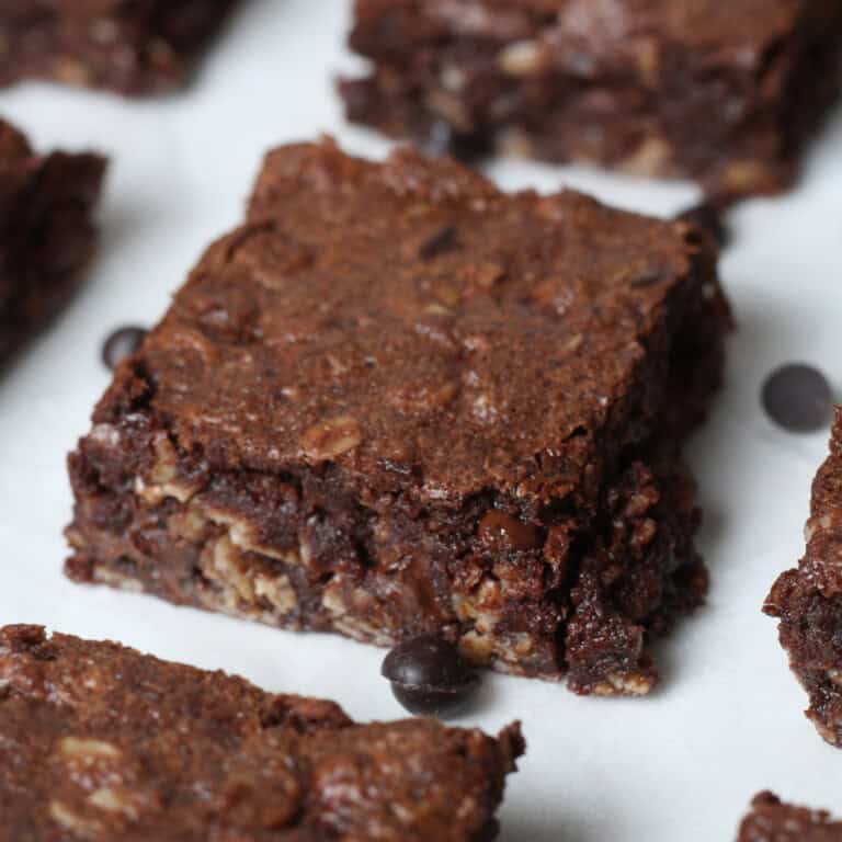 close up image of brownie baked oatmeal square on parchment paper