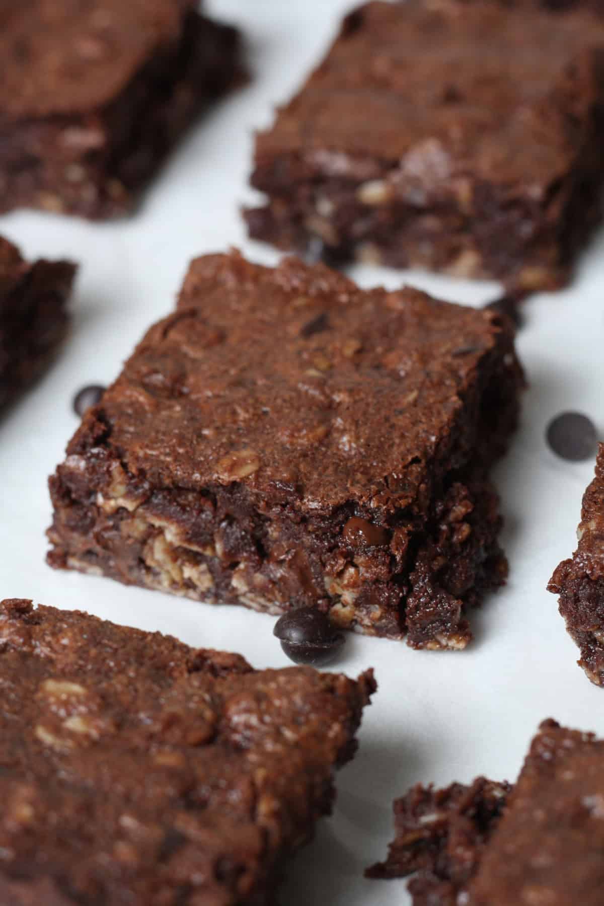 Close-up image of baked brownies with oatmeal squares on a cookie sheet with chocolate chips on the sides