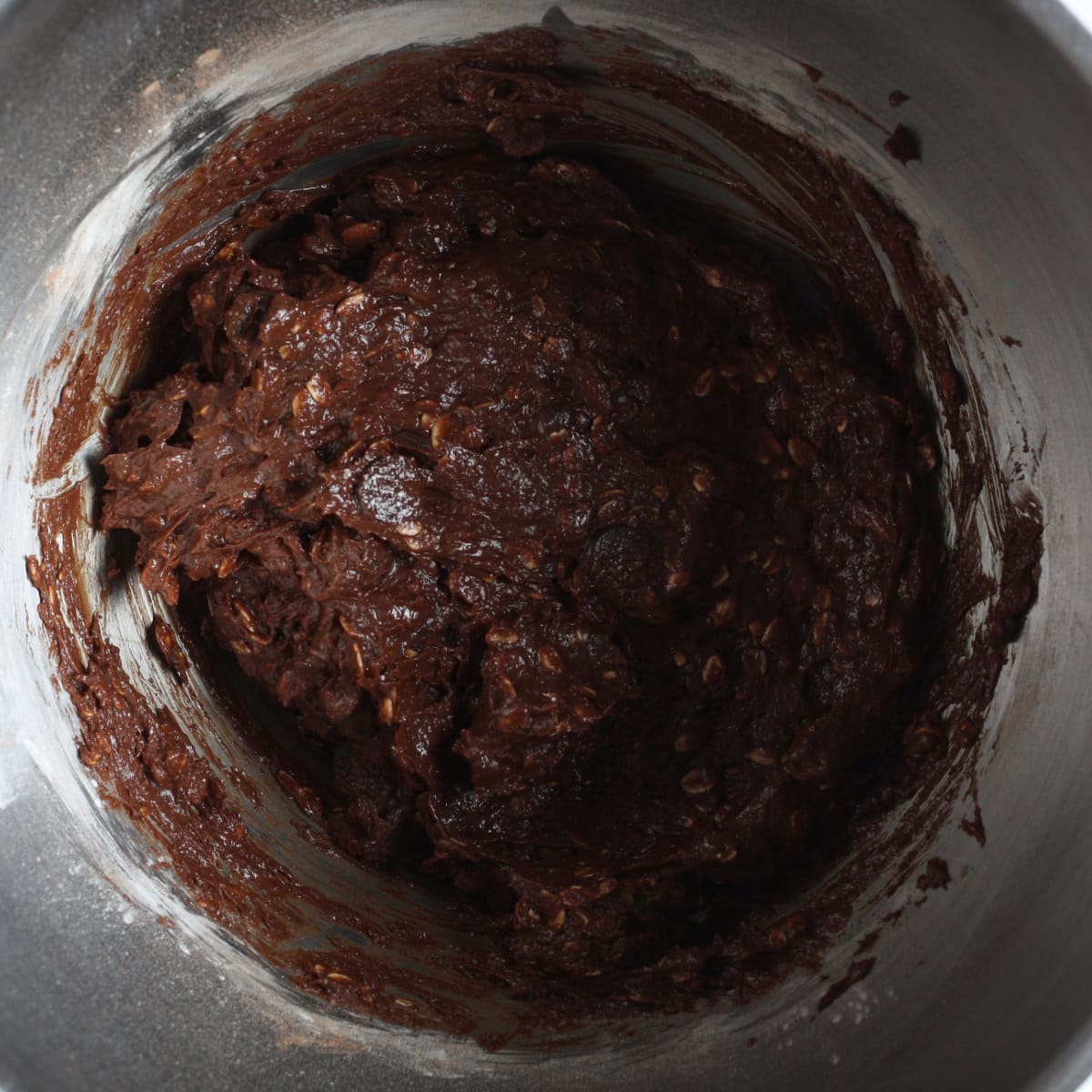 step by step of making the oatmeal brownies - adding the dry ingredients to the wet ingredients to form the dough