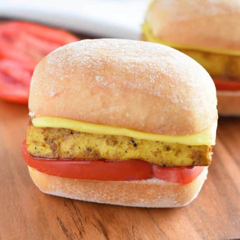 Vegan breakfast sandwich with egg and cheese on a wooden board