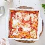 close up image of vegan baked ziti served in a casserole baking pan garnished with parsley on top - feature image