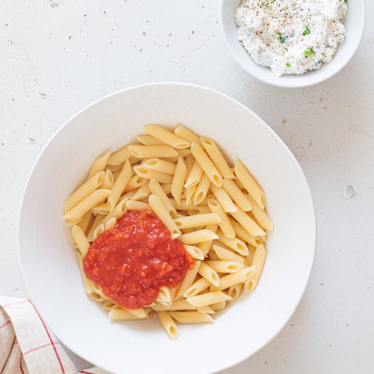 making the ziti mixture by adding the boiled penne pasta to the tomato sauce