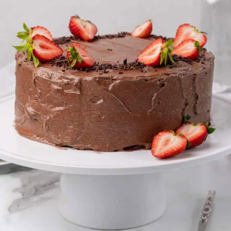 vegan chocolate cake topped with fresh strawberries