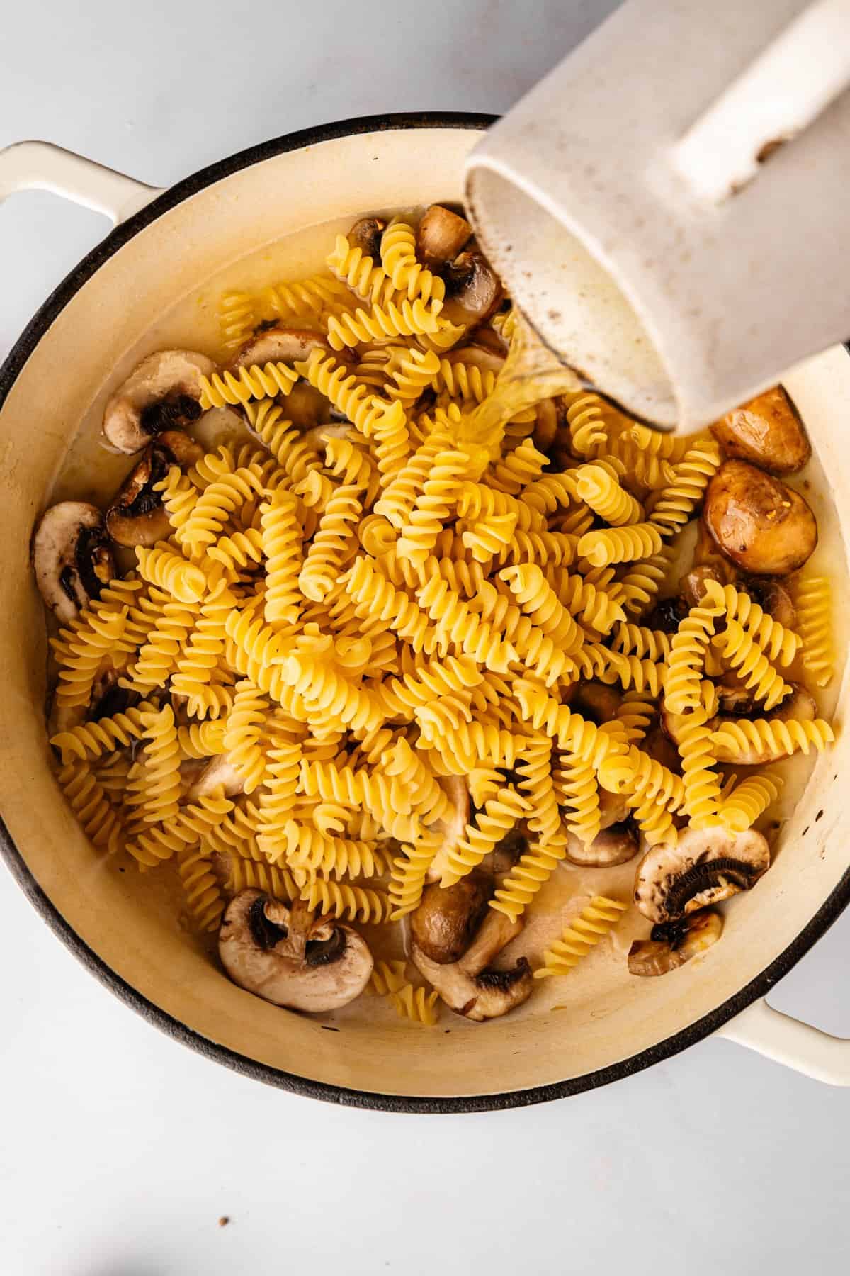 Adding dry fusilli pasta directly to the pot with saut&eacute;ed mushrooms for one-pot cooking