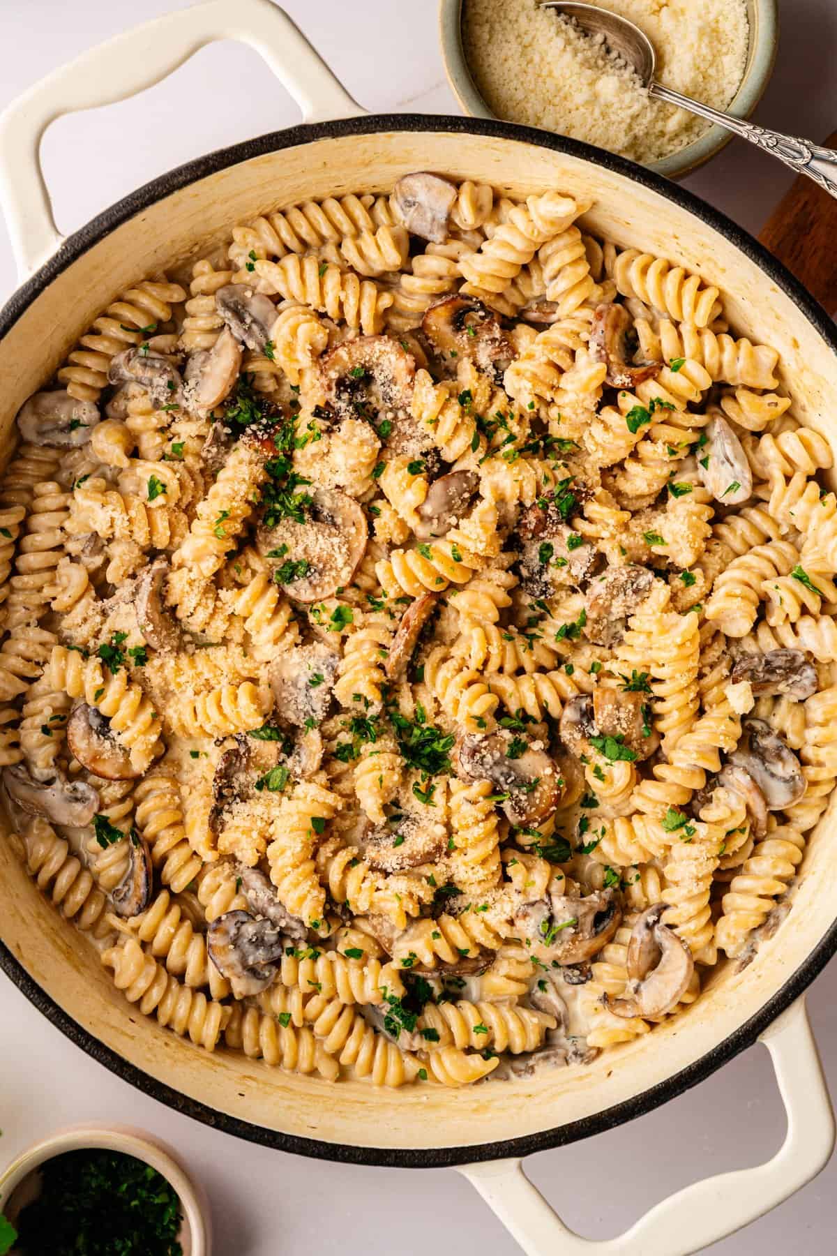 A pan of creamy mushroom ricotta pasta with saut&eacute;ed portobello mushrooms and grated Parmesan cheese
