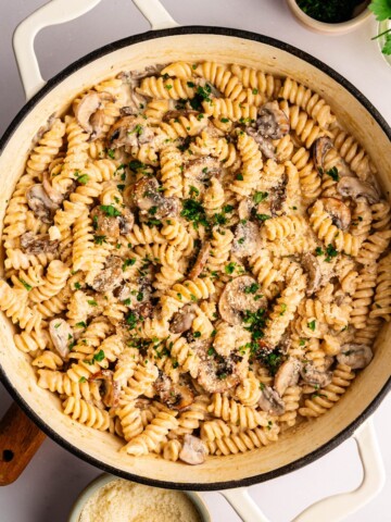 One-pot mushroom ricotta pasta in a white pan topped with Parmesan and black pepper