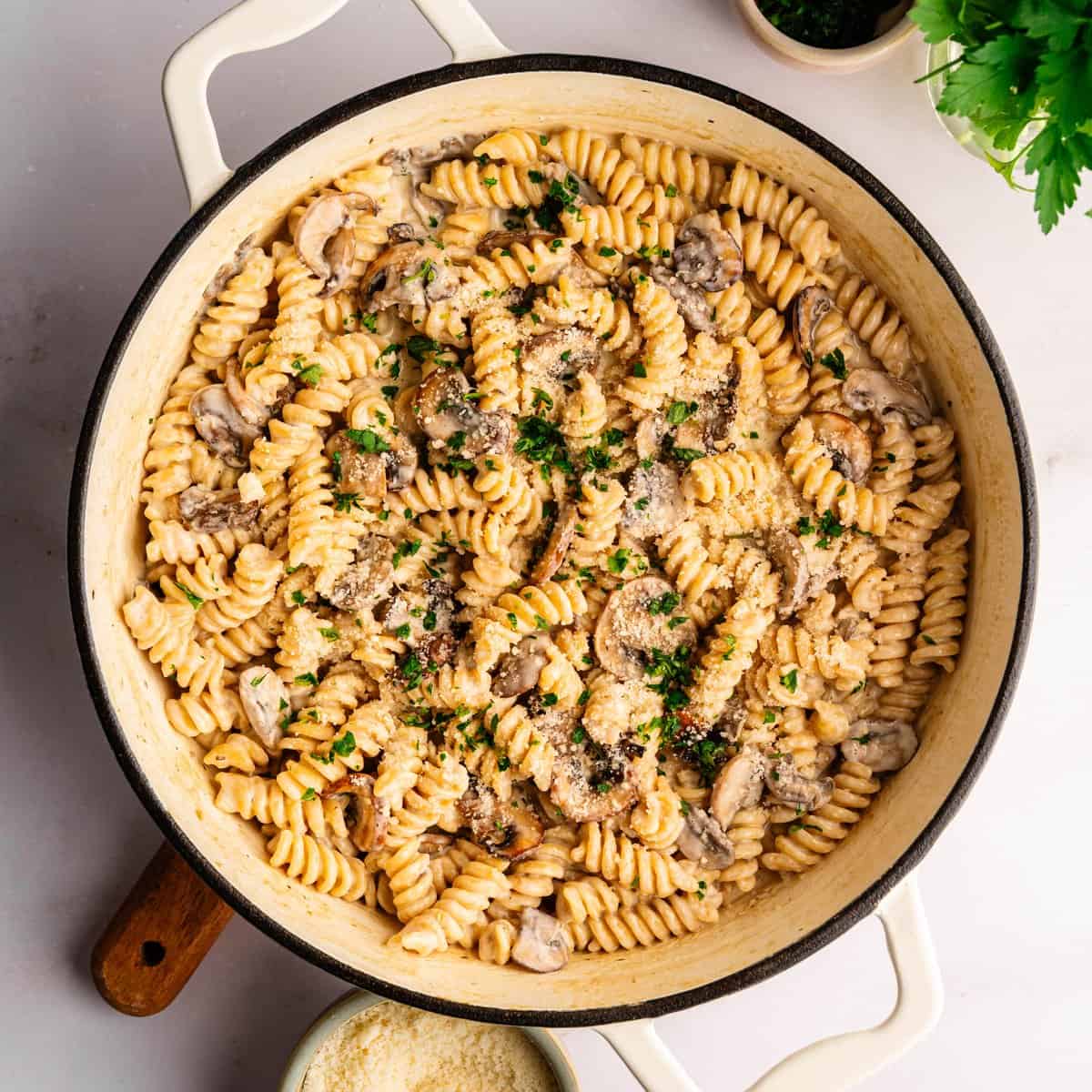 One-pot mushroom ricotta pasta in a white pan topped with Parmesan and black pepper