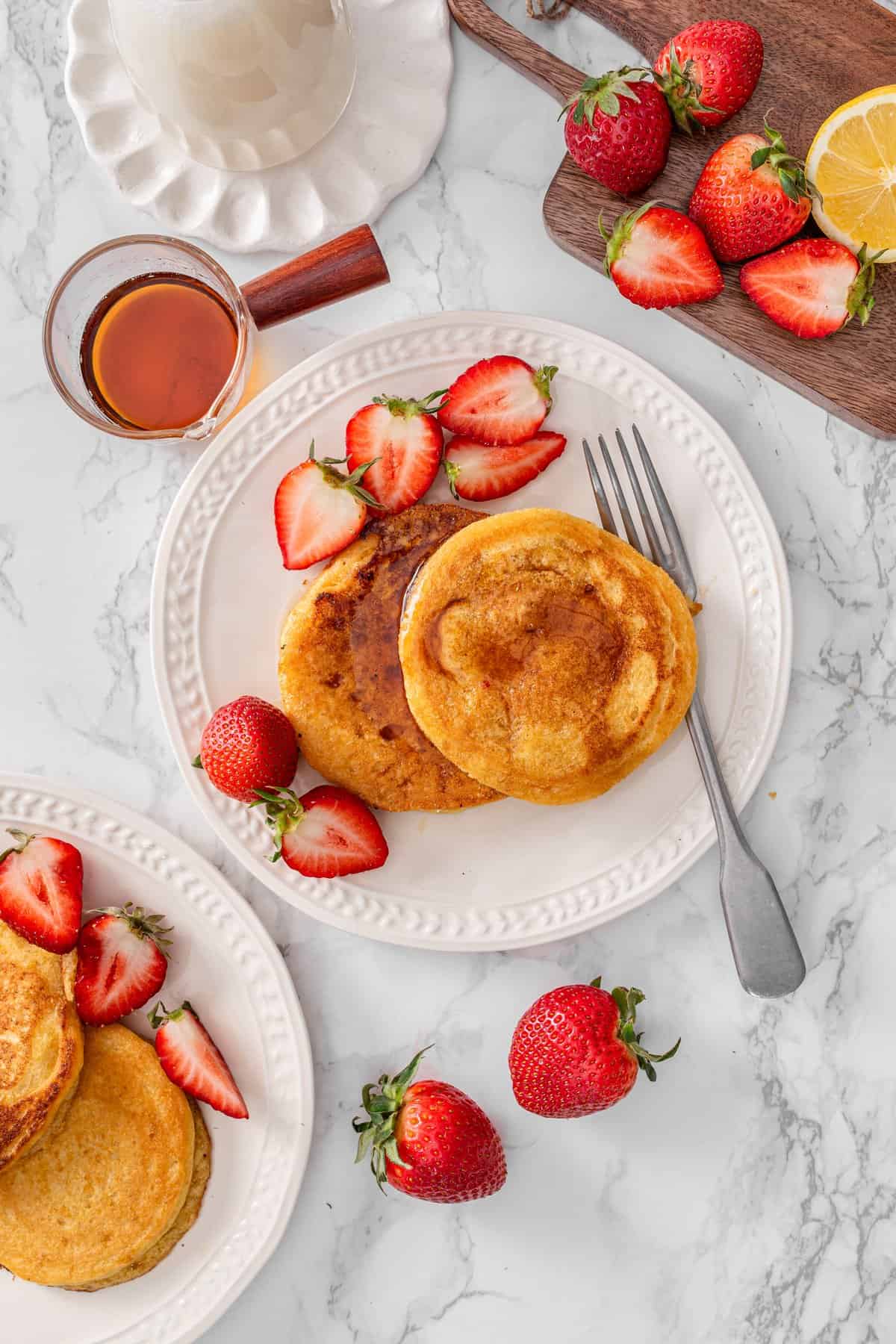 Chickpea flour pancakes served with fresh strawberry, and a drizzle of maple syrup