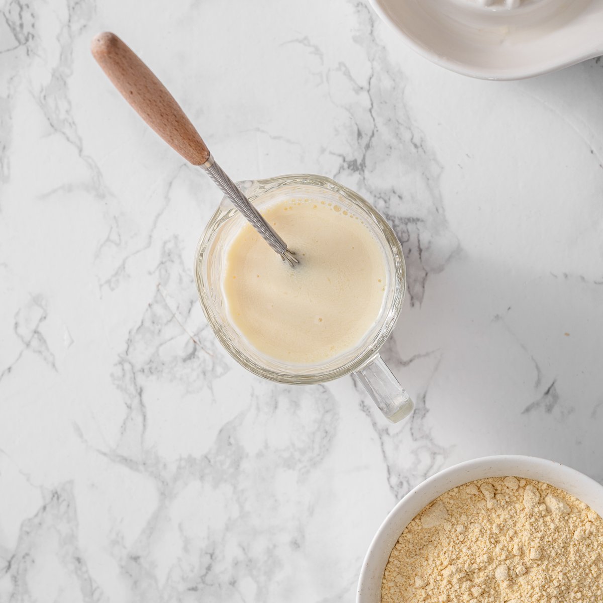 Soy milk and lemon juice combined in a measuring cup to make vegan buttermilk