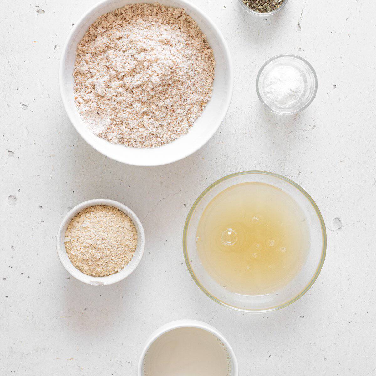 Ingredients for vegan almond flour biscuits laid out in small bowls