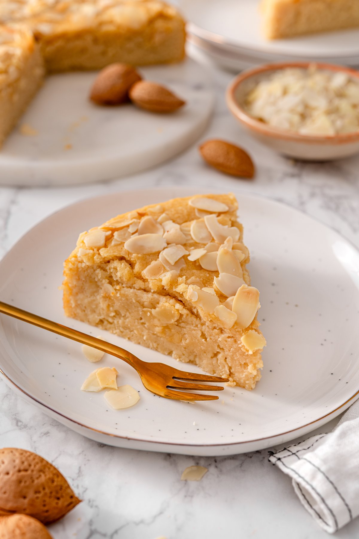 Slice of almond ricotta cake on a plate ready to serve