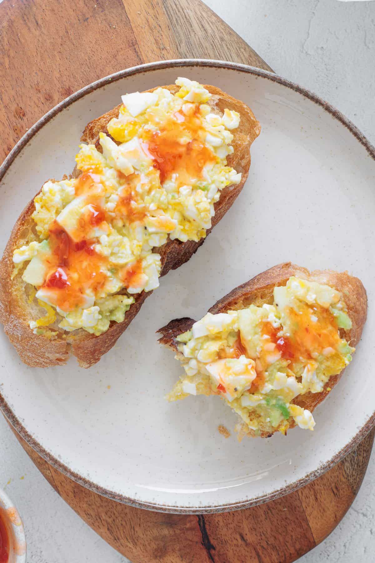 half eaten Avocado Cottage Cheese Toast on a white plate zoomed in
