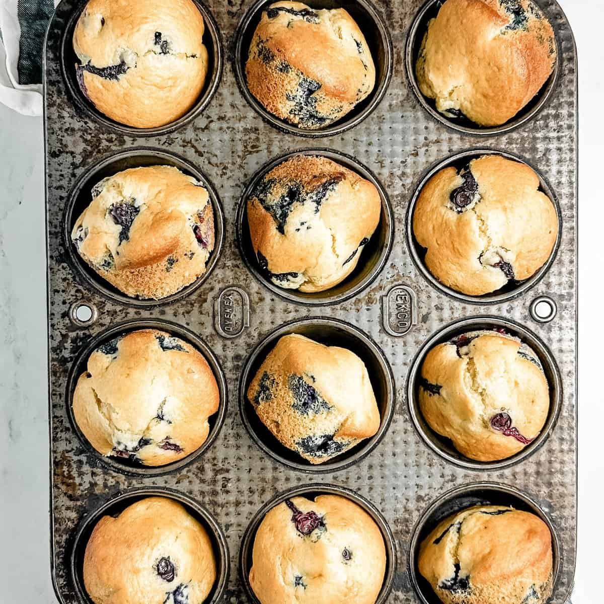 Dairy-free blueberry muffins preparation step 5 - Freshly baked on a baking sheet removed from the oven.