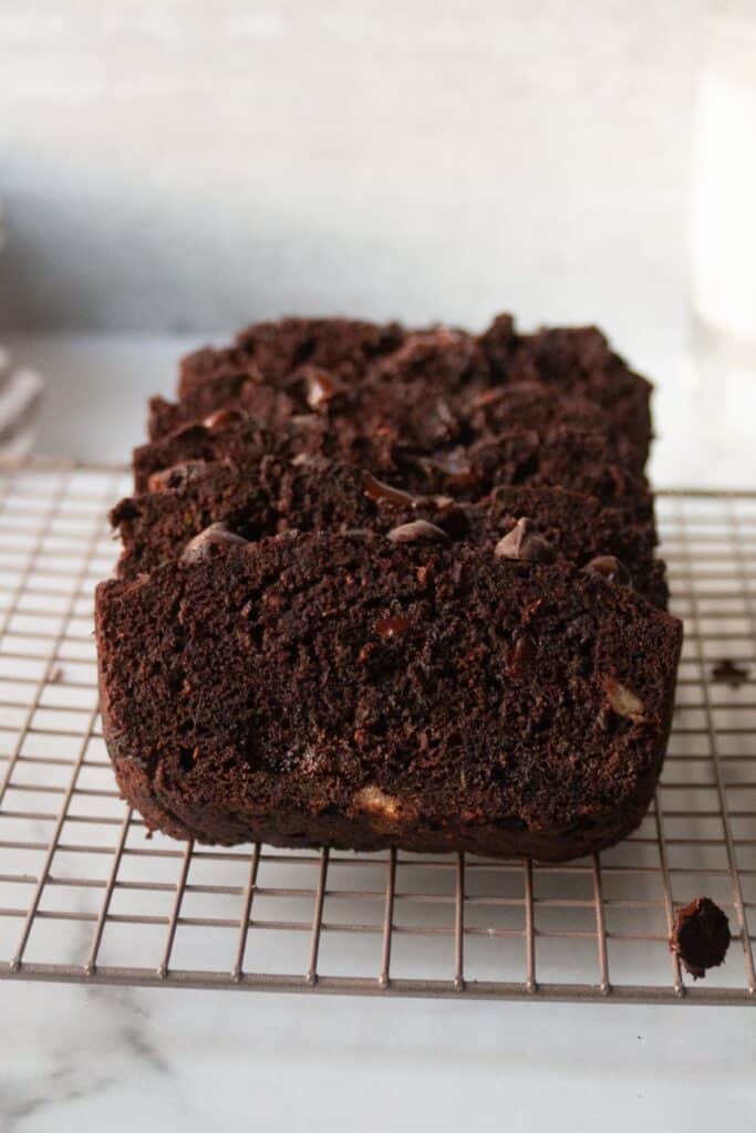 Sliced chocolate loaf cake on a wire cooling rack showing rich dark crumb with melted chocolate chips