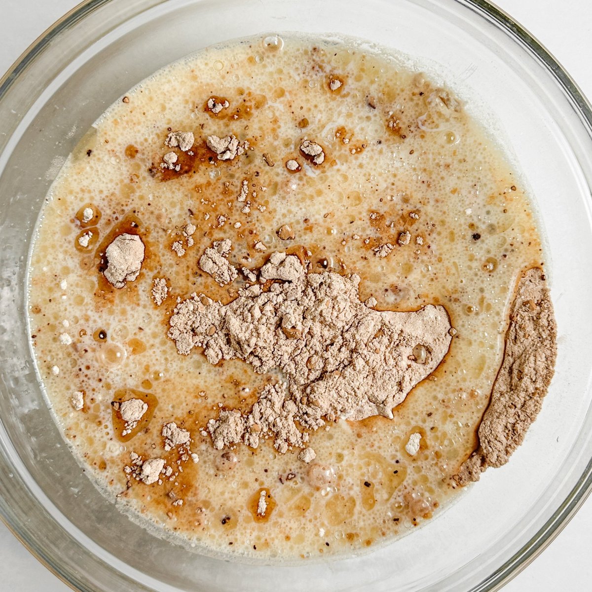 Chocolate loaf cake wet ingredients in a glass bowl with dry ingredients