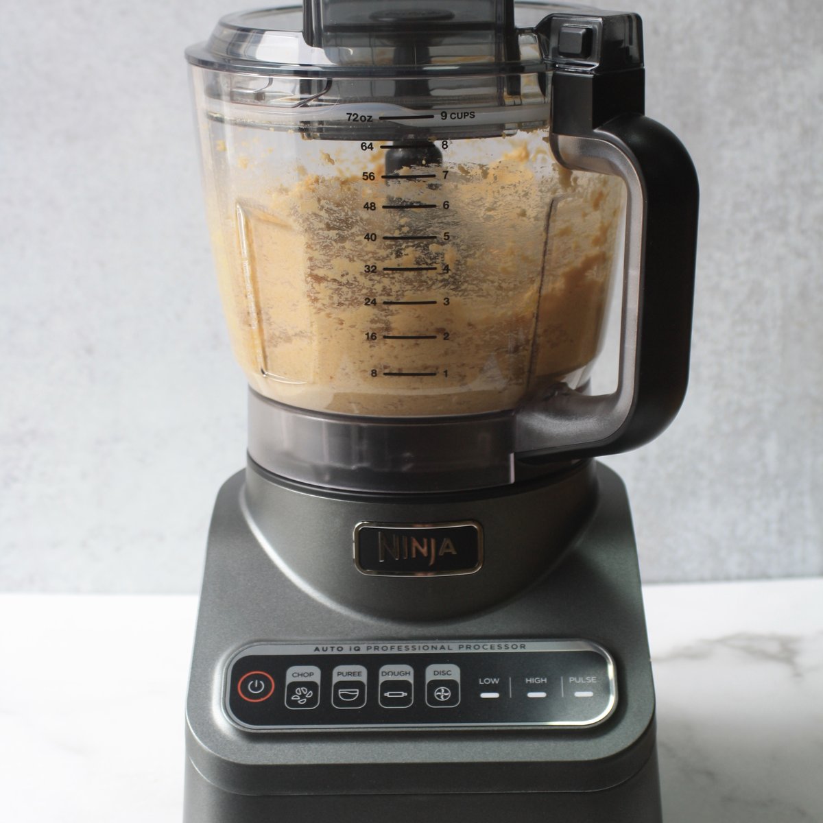 Ninja food processor blending chickpeas and creamy peanut butter into smooth chickpea cookie dough batter